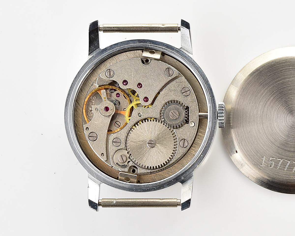 Open caseback view of mechanical wristwatch showing inner gears, listed as TIME CAPSULE POBEDA New Old Stock.