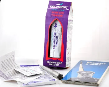 Space food souvenir set – empty Kosmopit cosmonaut soup tube, Soviet "First in the World" space postcards & aluminium rocket