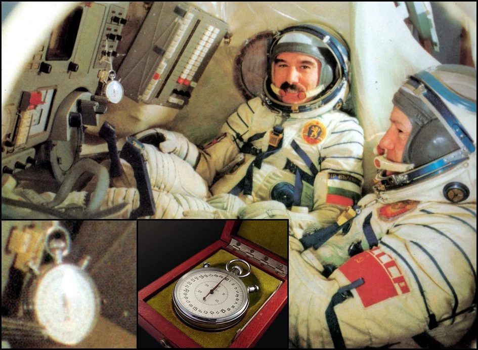 Soyuz cosmonauts in their capsule with a Soviet stopwatch mounted on the control panel